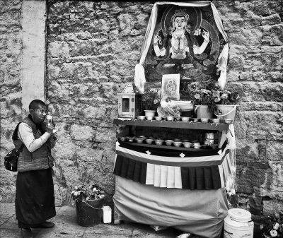 Tibetan Nun Praying at a Shrine